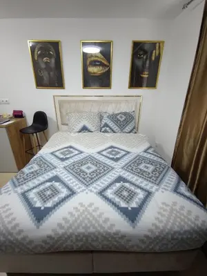 a bedroom with a bed with a blue and white quilt at Identity By Nights & Smiles in Tuzla