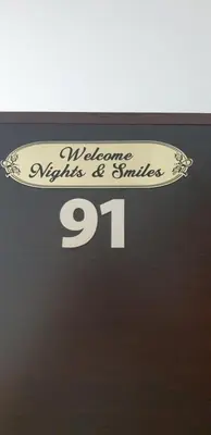 a sign that says welcome to syneys and smiles at Identity By Nights & Smiles in Tuzla