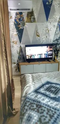 a bedroom with a bed and a tv on a wall at Identity By Nights & Smiles in Tuzla