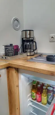 a kitchen with a coffee maker and an open refrigerator at Identity By Nights & Smiles in Tuzla