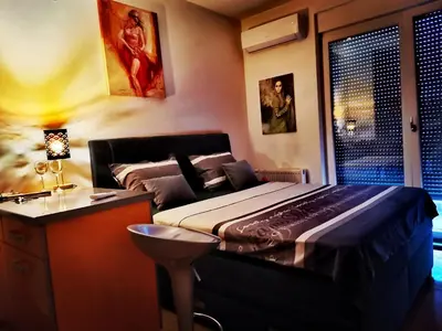 a bedroom with a bed and a desk and a window at Apartment CITY in Doboj