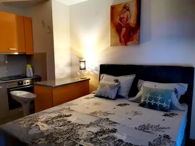 a bed in a small room with a kitchen at Apartment CITY in Doboj
