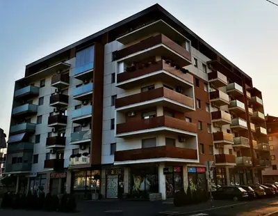 a large apartment building with balconies on a street at Apartment CITY in Doboj