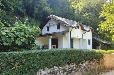 a white house with a hedge in front of it at Villa DIAL Lohovo-dvoslap in Bihać