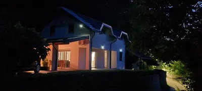 a white house with a blue roof at night at Villa DIAL Lohovo-dvoslap in Bihać