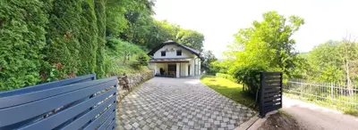 a house with a fence in front of a driveway at Villa DIAL Lohovo-dvoslap in Bihać