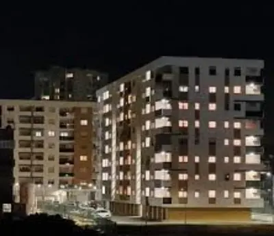 a tall apartment building at night with lights at Apartman La Valletta, Doboj in Doboj
