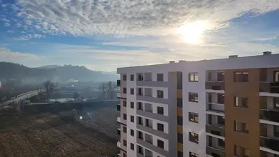 a view of a building with the sun in the sky at Apartman La Valletta, Doboj in Doboj