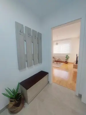 a living room with a bench on a wall at Apartman La Valletta, Doboj in Doboj