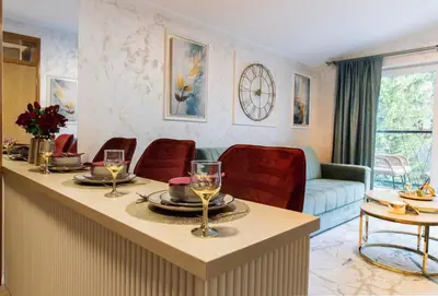 a living room with a table with wine glasses on it at Apartman Monti Vlašić in Vlasic