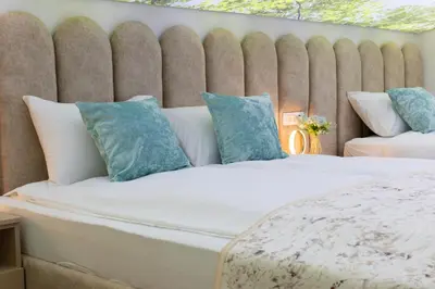 a bedroom with a large bed with blue pillows at Apartman Monti Vlašić in Vlasic