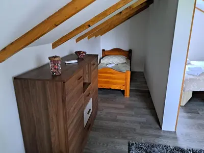 a bedroom with a wooden dresser and a bed at Kuca za odmor Šušnjar in Ripač