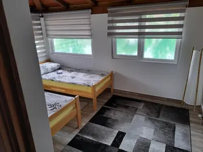 a small room with two beds and two windows at Kuca za odmor Šušnjar in Ripač