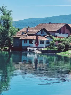 a house sitting next to a large body of water at Kuca za odmor Šušnjar in Ripač