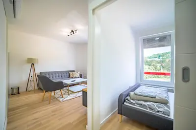 a living room with a couch and a window at Sun Square Apartments in Tuzla