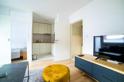 a living room with a tv and a yellow stool at Sun Square Apartments in Tuzla