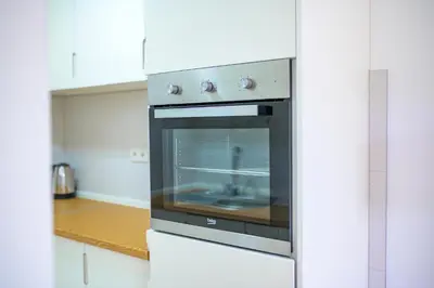 a kitchen with an oven in a white kitchen at Sun Square Apartments in Tuzla