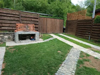 a backyard with a brick fireplace in the grass at Cottage Auto Camp Vinac in Jajce