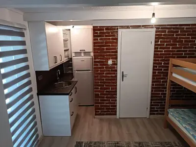 a kitchen with a brick wall and a white door at Cottage Auto Camp Vinac in Jajce