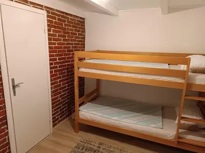 a room with bunk beds and a brick wall at Cottage Auto Camp Vinac in Jajce