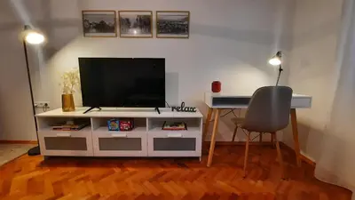a living room with a television and a chair at Babalina's Place in Bihać