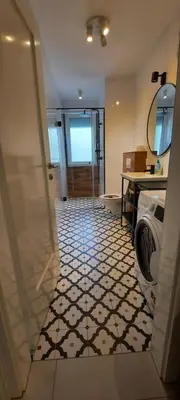 a bathroom with a washer and dryer on a tile floor at Babalina's Place in Bihać