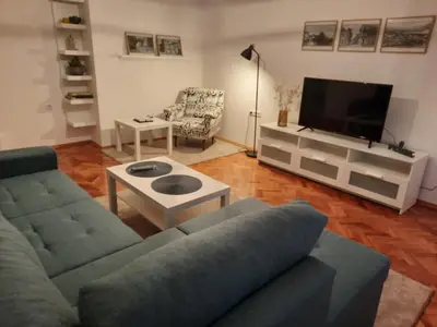 a living room with a couch and a tv at Babalina's Place in Bihać