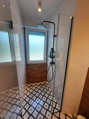 a bathroom with a shower and a window at Babalina's Place in Bihać