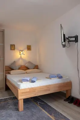 a bedroom with a bed and a tv on the wall at Orhideja Visoko in Visoko