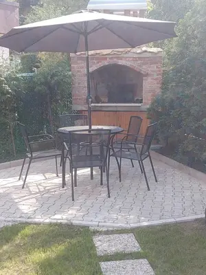 a table and chairs with an umbrella on a patio at Orhideja Visoko in Visoko