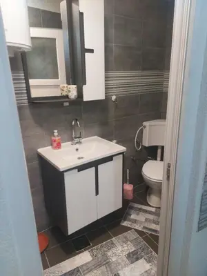 a bathroom with a white sink and a toilet at Orhideja Visoko in Visoko