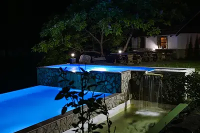 a swimming pool at night with blue lights at Prenoćište Slapovi in Jajce