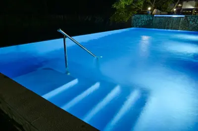 a swimming pool at night with blue lights at Prenoćište Slapovi in Jajce