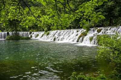 a waterfall in the middle of a body of water at Prenoćište Slapovi in Jajce