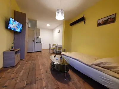 a bedroom with a bed and a table and a tv at Apartmani Sarti Banja Luka in Banja Luka