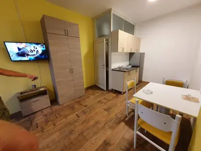 a room with a table and a kitchen with a television at Apartmani Sarti Banja Luka in Banja Luka
