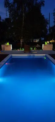 a swimming pool with a bench in a park at night at Apartman Brezuljak Banja Luka Cokorska polja in Macanovići