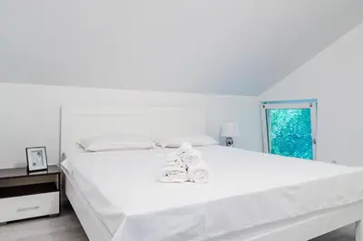 a bedroom with a white bed with shoes on it at Apartment Andrej in Tomislavgrad