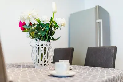 a vase with flowers in it sitting on a table at Apartment Andrej in Tomislavgrad