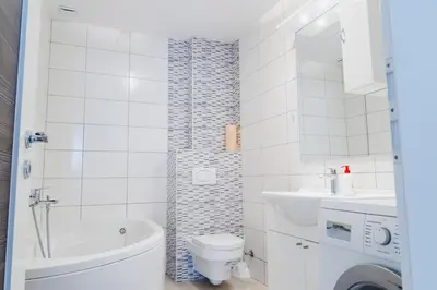 a white bathroom with a toilet and a sink at Apartment Andrej in Tomislavgrad