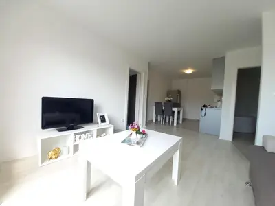 a white living room with a white table and a tv at Apartment Andrej in Tomislavgrad