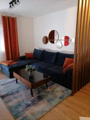 a living room with a blue couch and a coffee table at Prestige Apartment Teslic in Teslić