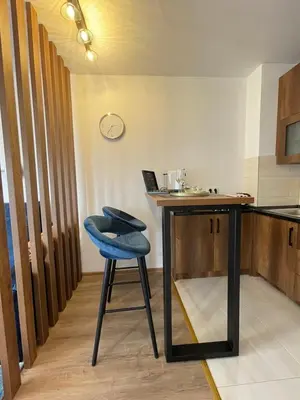 a table with a blue stool in a kitchen at Prestige Apartment Teslic in Teslić