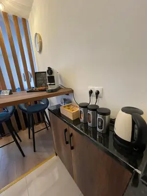 a kitchen with a counter with a microwave and a desk at Prestige Apartment Teslic in Teslić