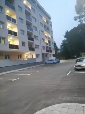 a parking lot in front of a large apartment building at Prestige Apartment Teslic in Teslić