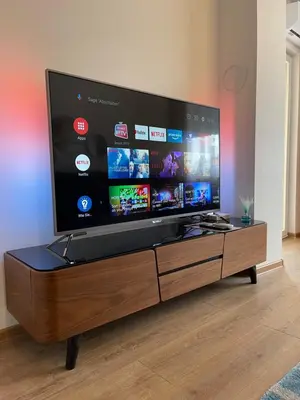 a large flat screen tv sitting on a wooden entertainment center at Prestige Apartment Teslic in Teslić