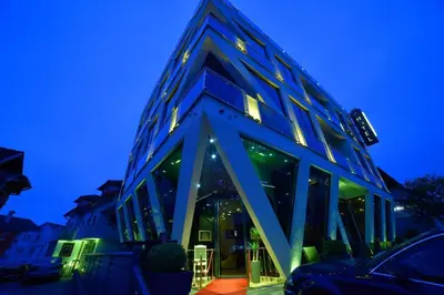 a blue building with a lot of windows at night at Hotel PALACE in Velika Kladuša