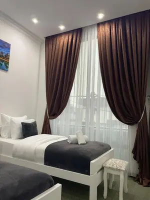 a bedroom with a bed and a window with curtains at Hotel PALACE in Velika Kladuša