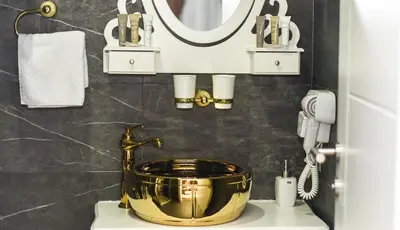 a bathroom with a copper bucket on a sink at Hotel PALACE in Velika Kladuša