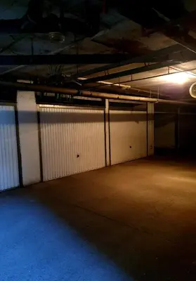 an empty parking garage with white garage stalls at Apartman Basic Doboj in Doboj
